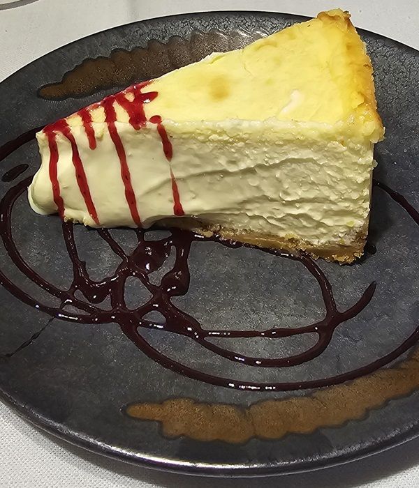 Postre del Restaurantes Graccurris de Alfaro de tarta de queso con sirope de frutos rojos